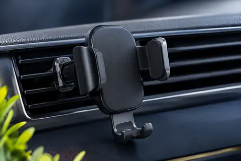 Support voiture AINOPE noir à bras gravitationnels fixé sur une grille d’aération horizontale