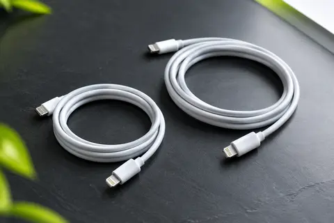 Deux câbles Lightning blancs BSTOEM de 1 m et 2 m disposés sur un fond ardoise