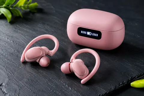 Écouteurs sport rose avec crochets d’oreille, embouts en silicone et boîtier de charge à affichage LED
