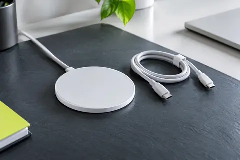 Chargeur sans fil magnétique COCOCKA blanc et compact, accompagné de son câble sur un bureau sombre
