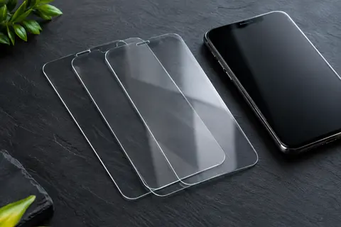 Trois protections d’écran transparentes en verre trempé présentées sur un fond ardoise.