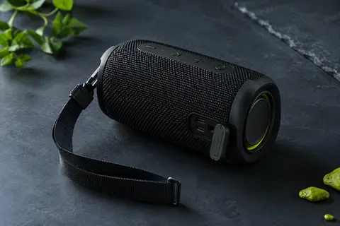 Enceinte Bluetooth portable noire MIFA A1 avec sangle amovible, présentée sur fond ardoise