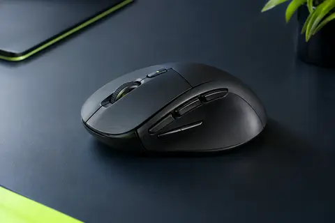 Souris TECKNET noire mate à six boutons présentée sur un bureau contemporain au fond ardoise.