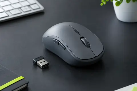 Souris sans fil TECKNET grise avec molette centrale et petit récepteur USB nano sur un bureau