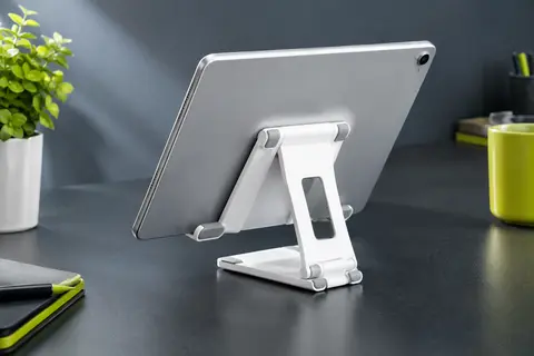 Support de bureau pliable blanc UGREEN tenant une tablette sur une table, avec son inclinaison réglable.