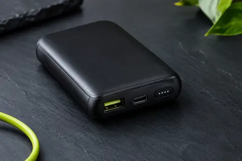 Batterie externe VRURC noire compacte avec écran LED et plusieurs ports USB sur fond ardoise